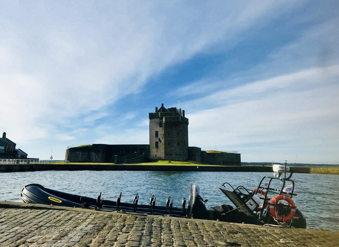 Broughty Ferry Castle with boat at the side of the dock
